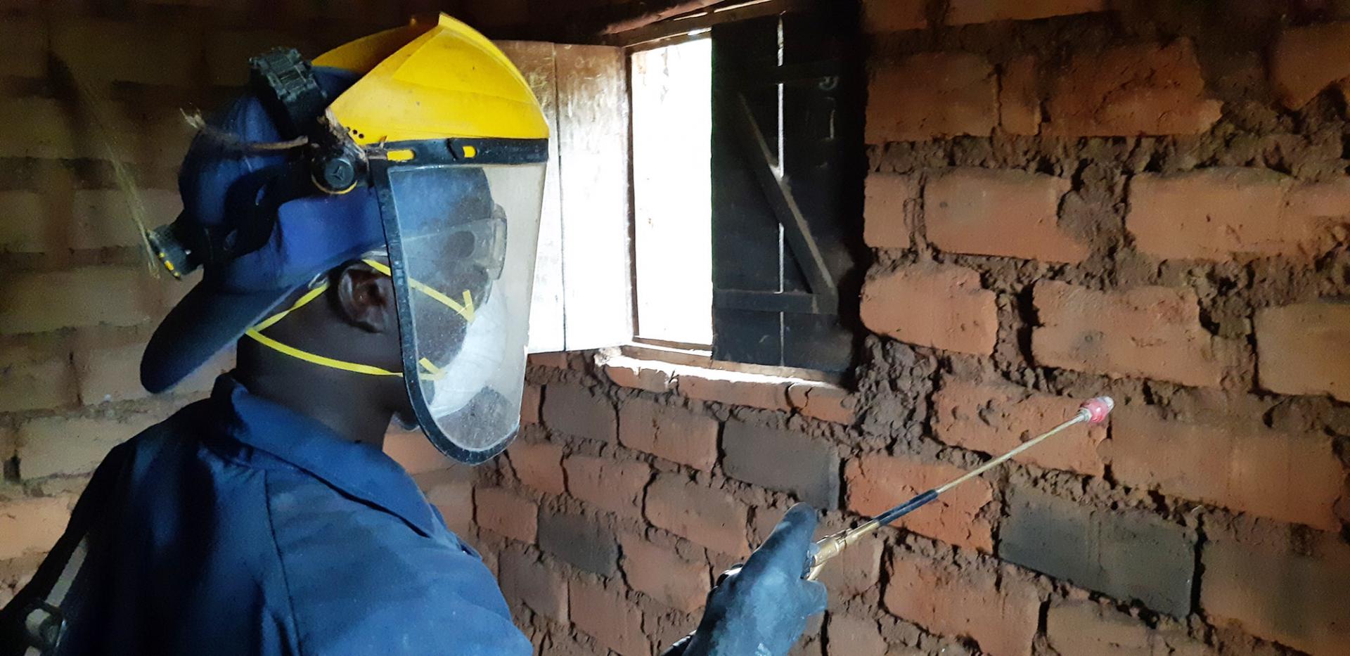 A sprayer is treating a house against mosquitoes during the 2019 indoor residual spraying campaign in Kinyinya health district.