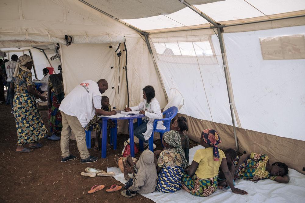 Displaced women and children wait their turn for a medical consultation in a tent of the MSF mobile clinic