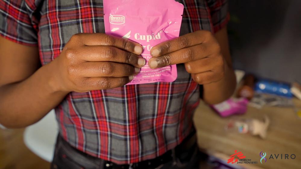 A girl showing how to use a female condom