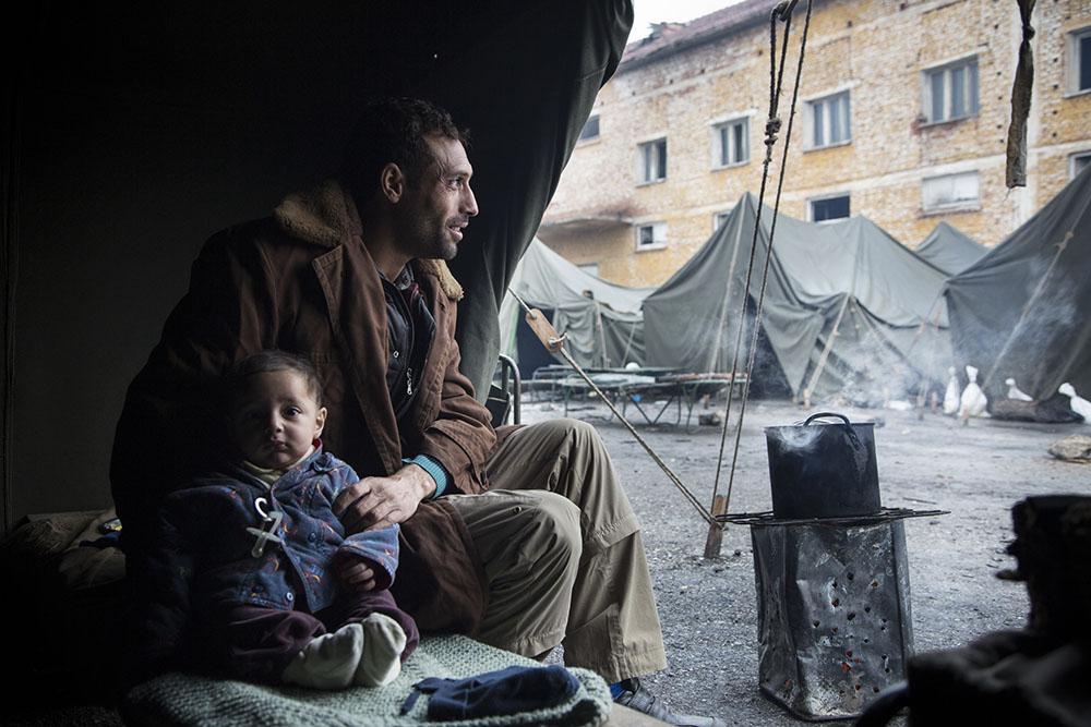 A Syrian man and his infant son sit in their tent at Harmanli Camp, a former military installation in Bulgaria. A major increase in the number of migrants crossing into Bulgaria in recent months has strained Bulgaria's existing system. Authorities have quickly moved migrants into makeshift facilities including abandoned schools, tents, containers and military barracks. 