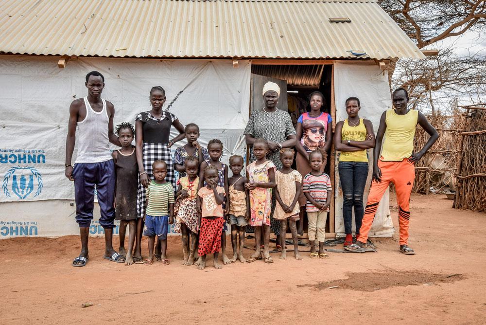 Nyakun Kuok and her family standing outside her house in Dagahaley camp