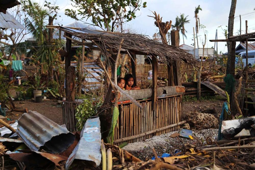 Two children in a destroyed home in the Philippines