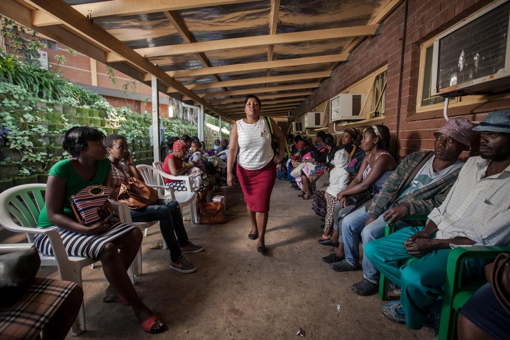 MSF staff passing a long queue of patients at Eshowe Gateway Clinic to pick up ARVs for members of her Community ART Group