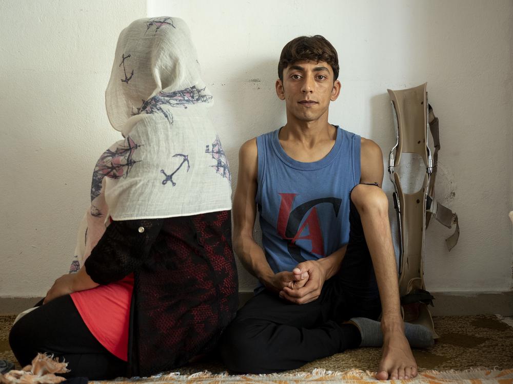 A husband and wife sitting side by side on the floor