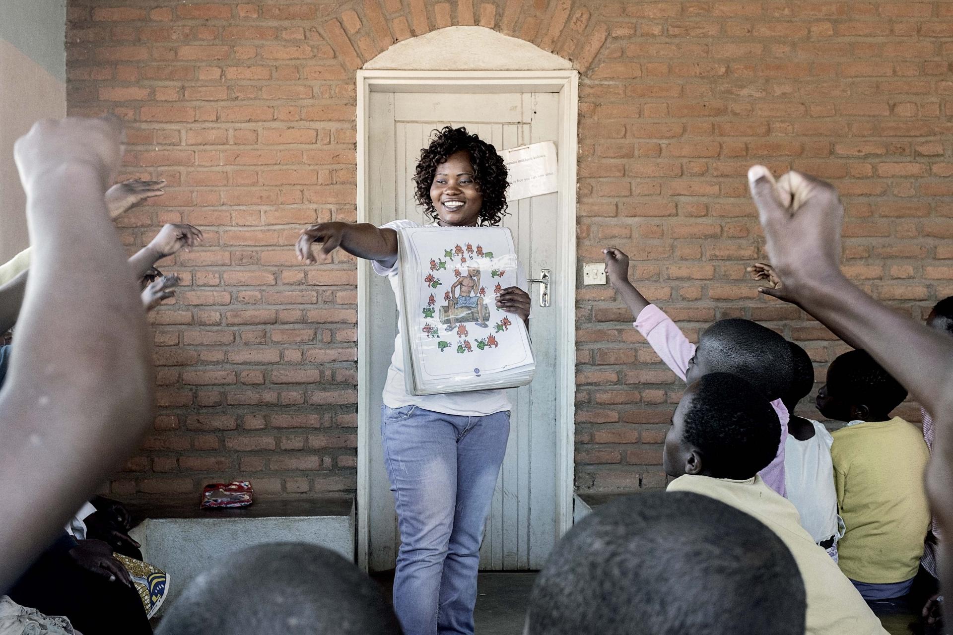 MSF counsellor Charity stands in the middle of HIV positive adolescents as she gives them the basic infos about the virus during an educational session at Mbulumbuzi Health Centre, Malawi.