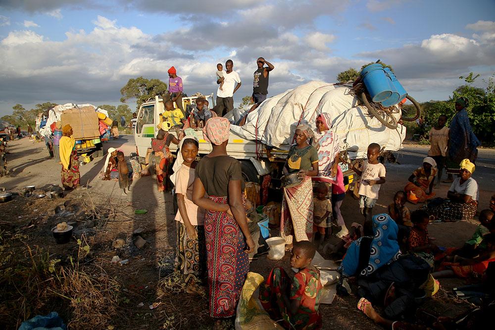 People displaced by the conflict in Cabo Delgado, a northern province in Mozambique, wait next to a truck on the outskirts of Mueda. They had previously been resettled in other areas of the province but are now aiming to reach Palma, a coastal town that was attacked earlier this year and where some people have already gradually returned. 