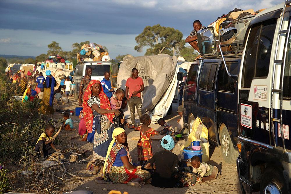 People displaced by the conflict in Cabo Delgado, a northern province in Mozambique, wait next to a truck on the outskirts of Mueda. They had previously been resettled in other areas of the province but are now aiming to reach Palma, a coastal town that was attacked earlier this year and where some people have already gradually returned. 