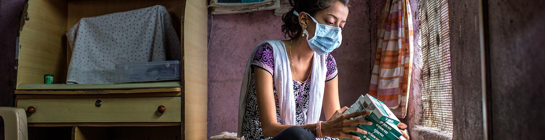 An XDR-TB patient looking at her boxes of TB medication in Mumbai, India