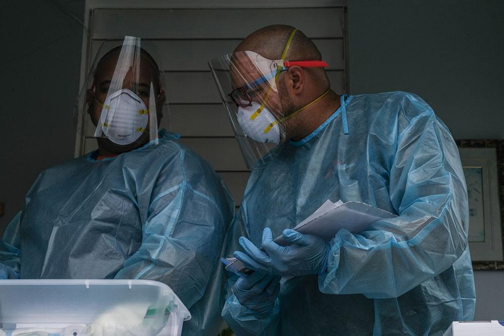 MSF physician Dr. Jonathan Caldera and MSF nurse Omar Martinez evaluate a patient during an in-home medical consultation in the community Buen Consejo in Rio Piedras, Puerto Rico. MSF’s home-based care model was designed to serve people who have little to no access to health care, including marginalized and isolated communities.