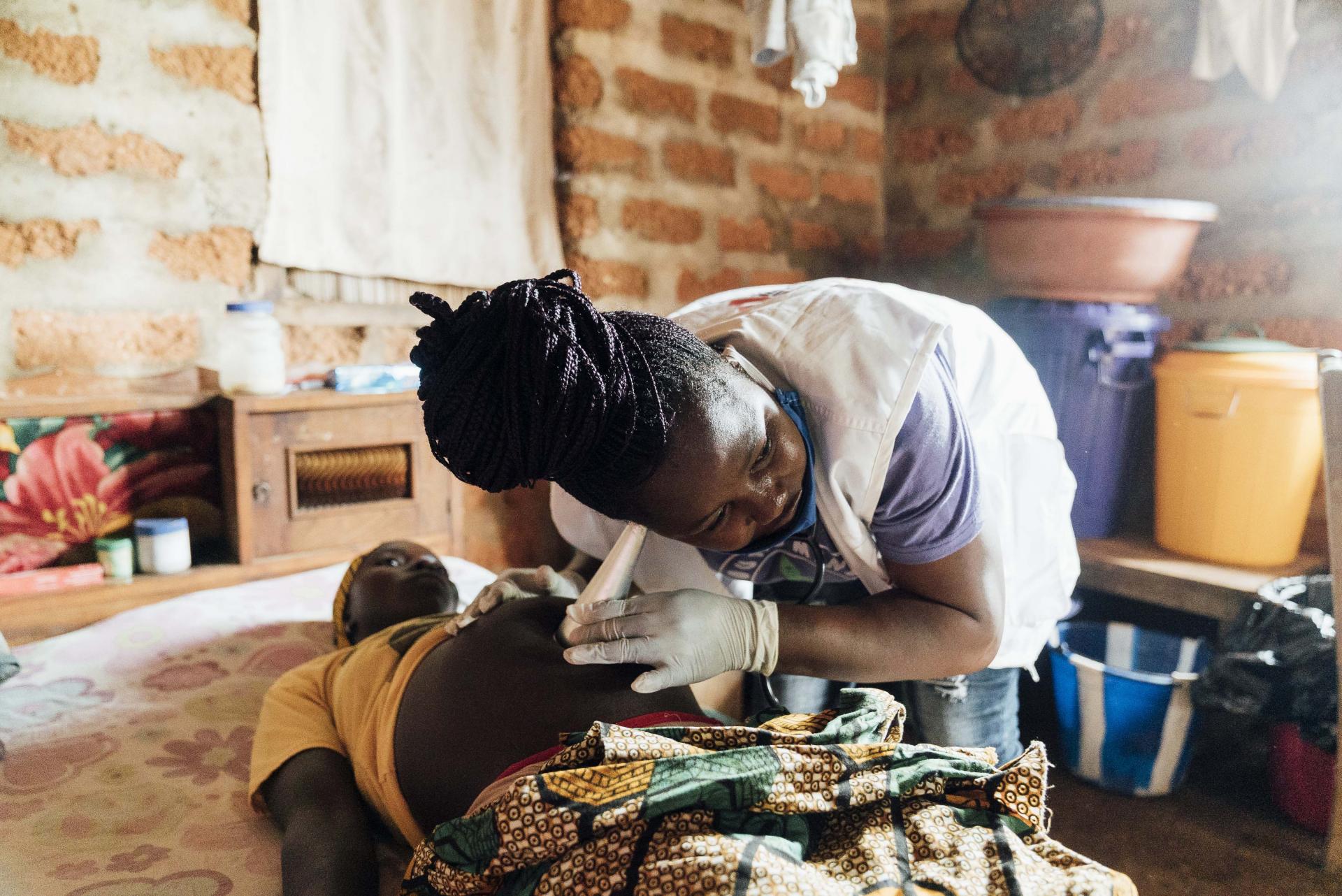 Midwife Sia Kallon listens to the heartbeat of 30-year old Baidu Jinnah Sheriff’s unborn baby, Sierra Leone