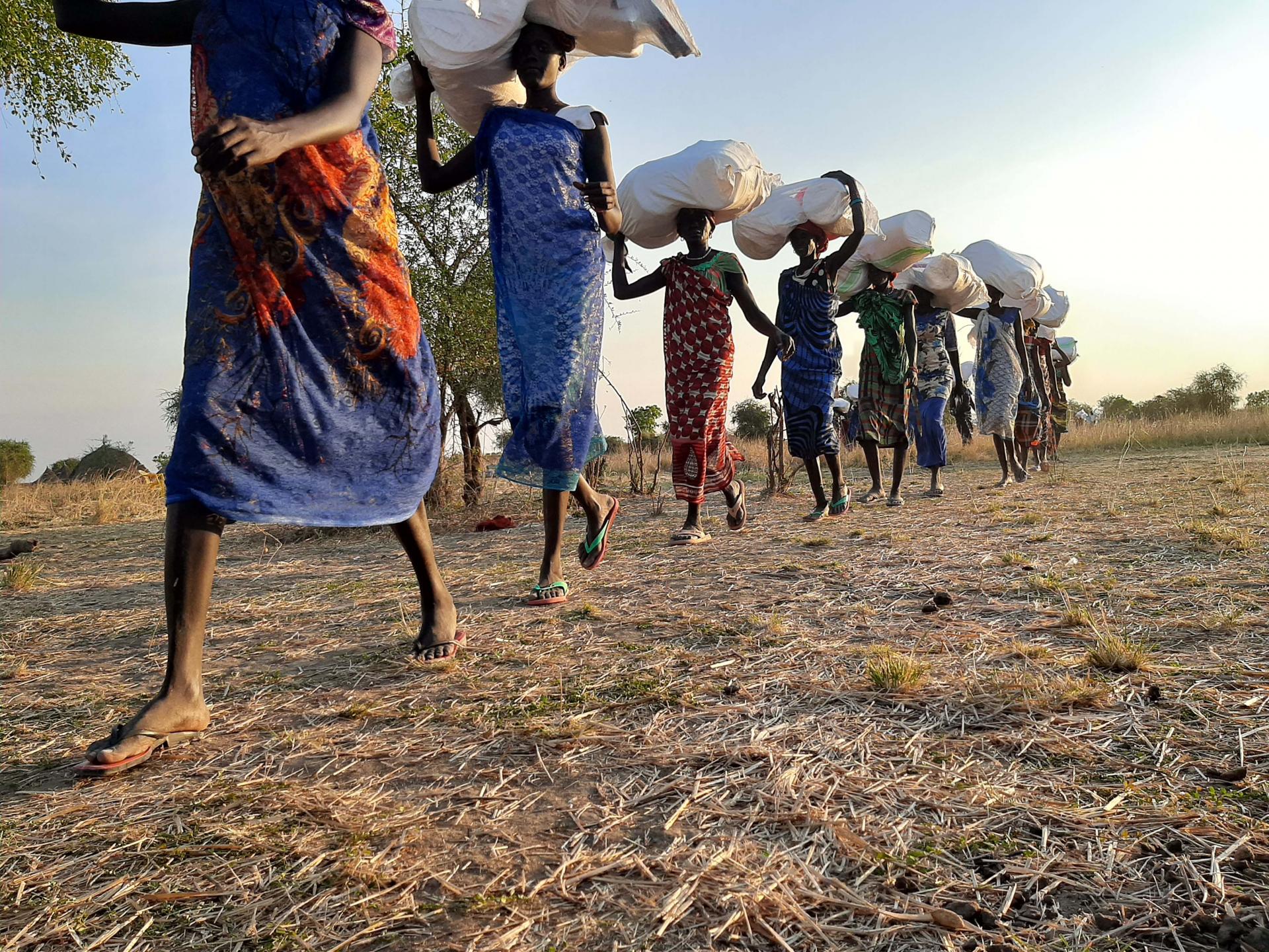 Women from Riang, Jonglei state, carry items that MSF will distribute to local families, South Sudan