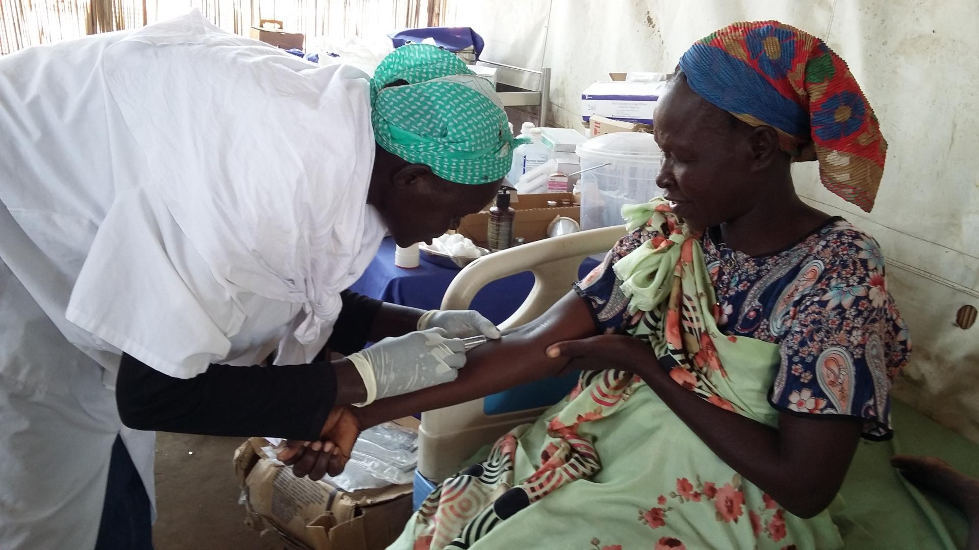 A patient receiving a vaccine from an MSF nurse in Sudan