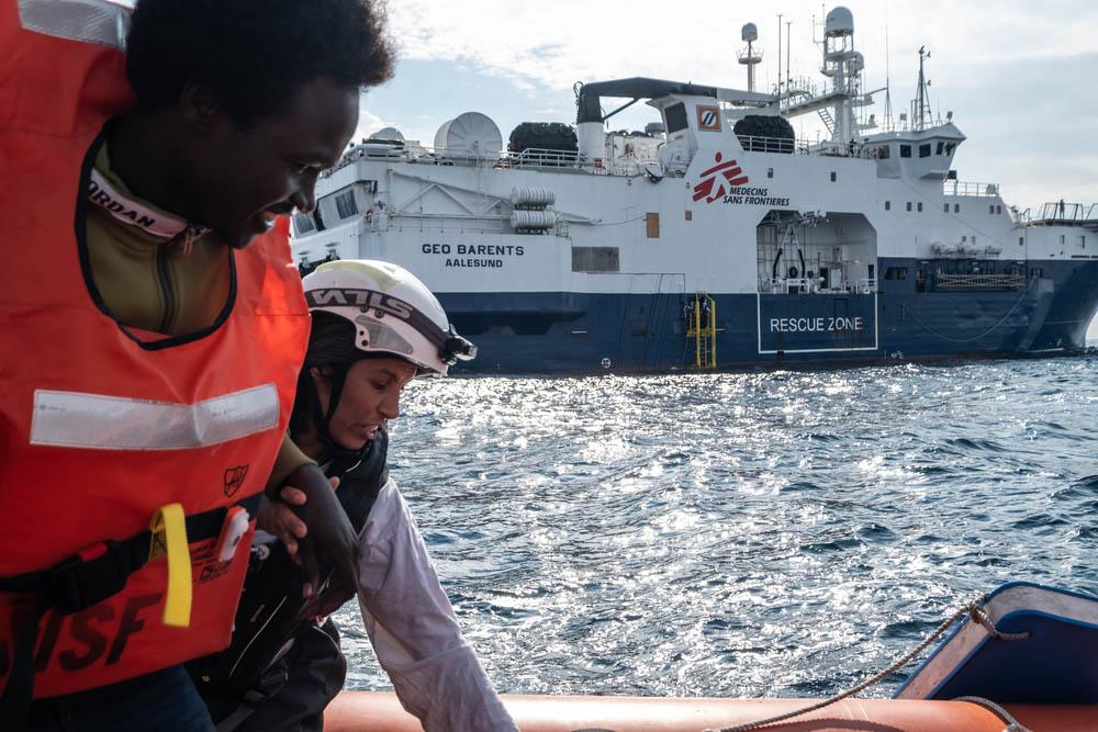 MSF Cultural Mediator Nejma helps a survivor on one of the Rigid Hull Inflatable Boats