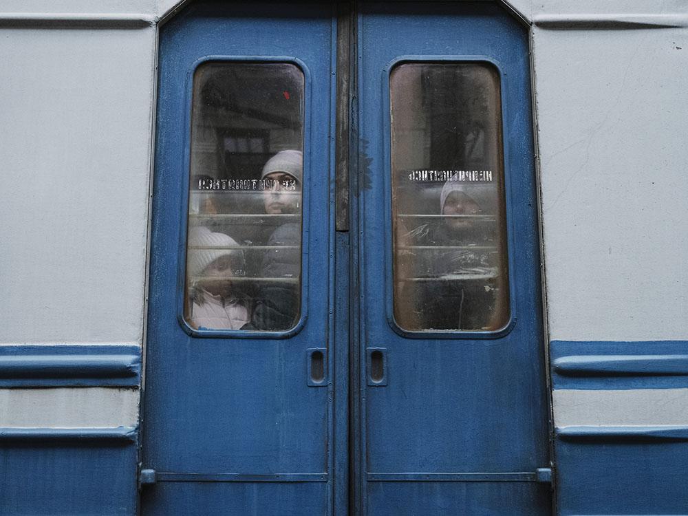 UKRAINE. Lviv. 26 February 2022. Children seen through the window of an evacuation train traveling towards the border with Poland as thousands of people try to escape the on-going conflict in Ukraine. 