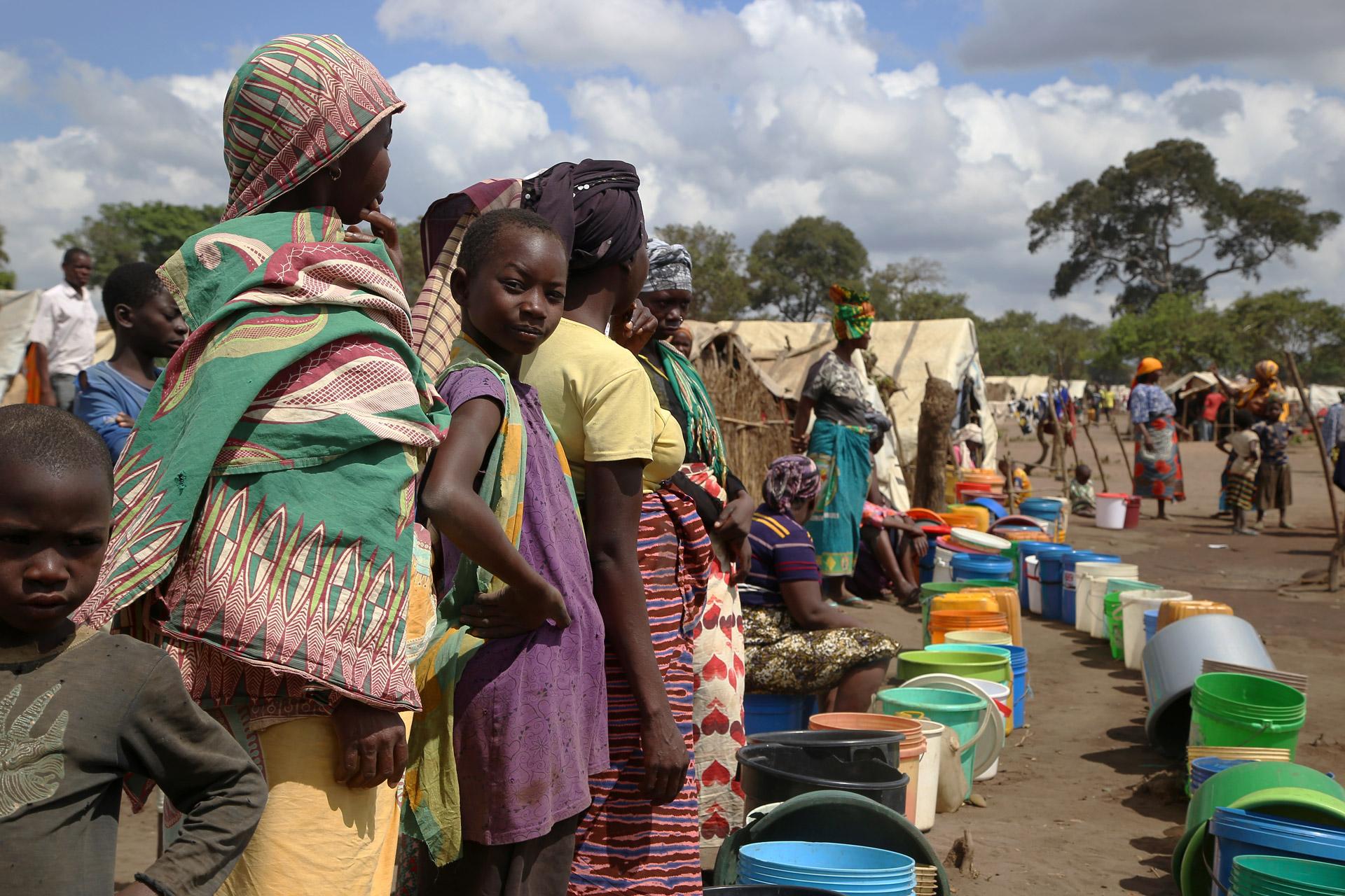 Women and girls queue at a water point in Eduardo Mondlane, Mozambique