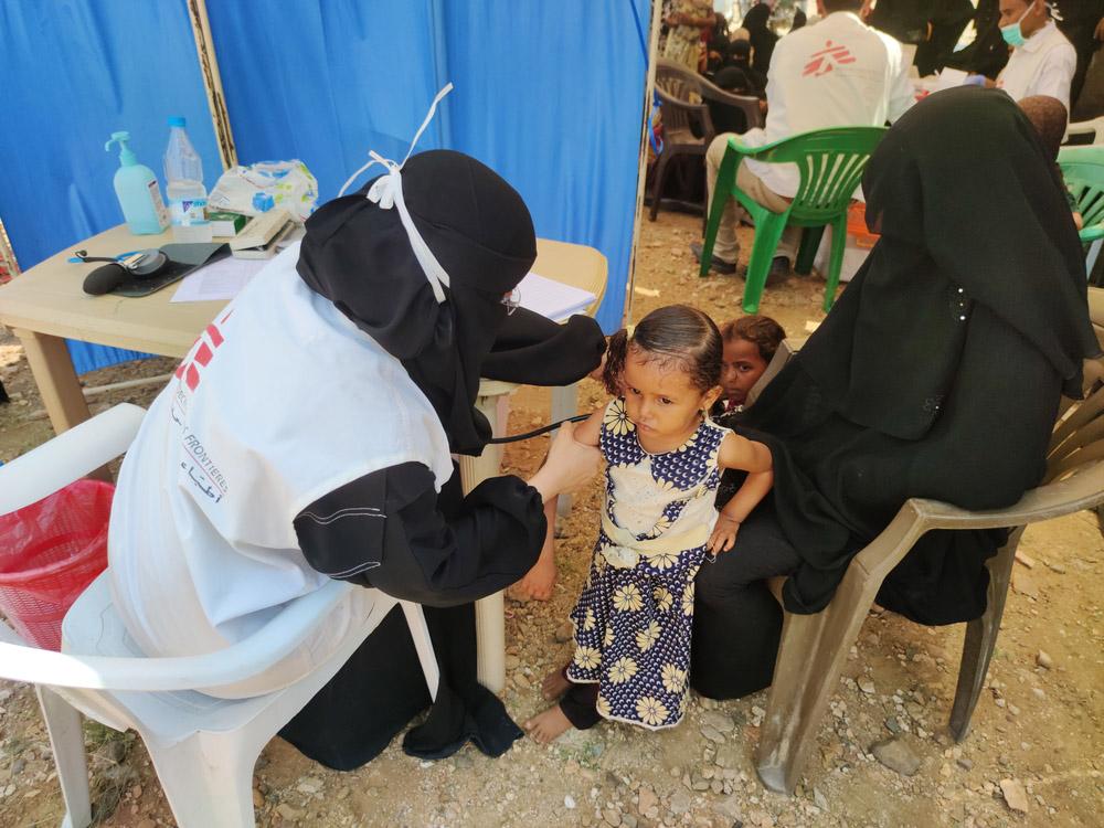 A picture of an MSF staff member giving a child a medical check up