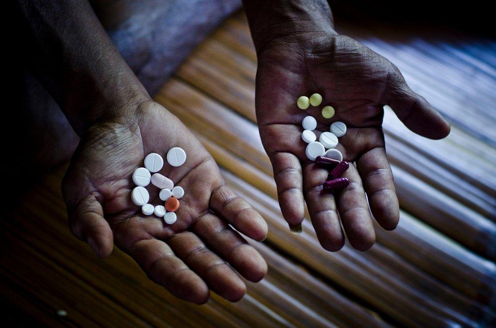 MDRTB patient Seikholien, 45, is showing his daily dose of pills given to him by the MSF staff nurse.
