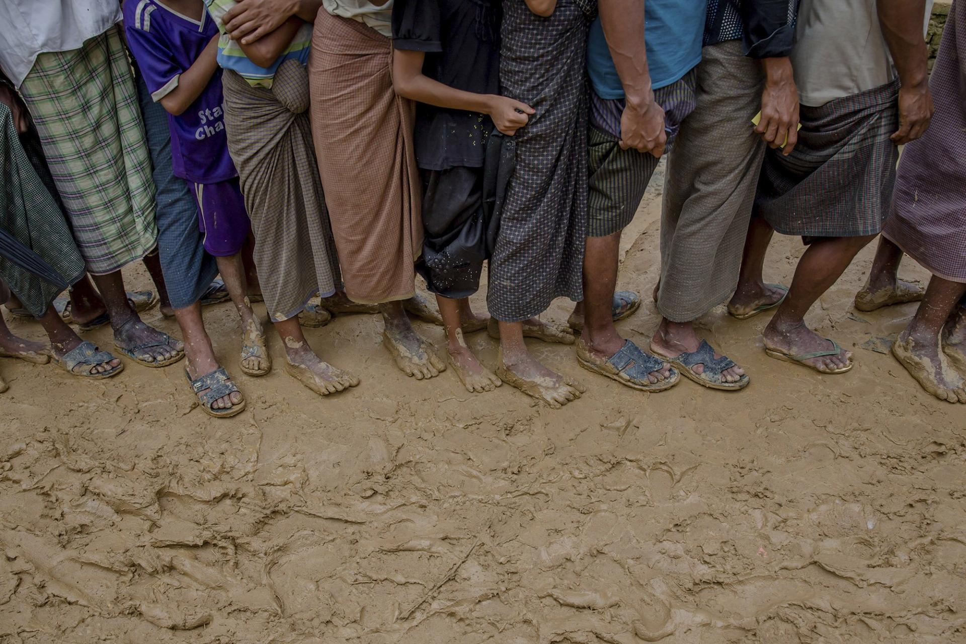Newly arrived Rohingya wait for their turn to collect building material for their shelters distributed by aid agencies in Kutupalong refugee camp, Bangladesh, Wednesday, Sept. 13, 2017. 