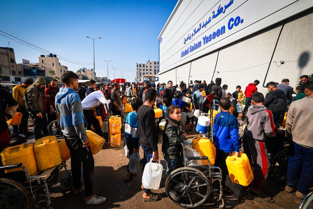 Palestinian residents queue for water in Gaza