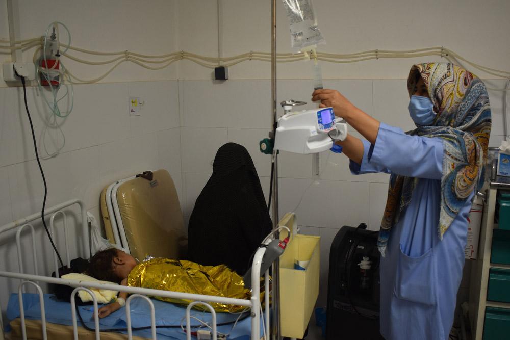 MSF nurse Fatima, pictured giving IV fluid to a malnourished child