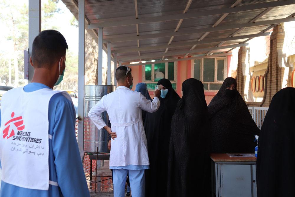 MSF staff ushering patients into the hospital in Afghanistan