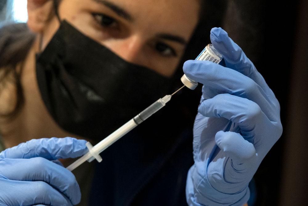 A picture of an MSF staff member administering a vaccine