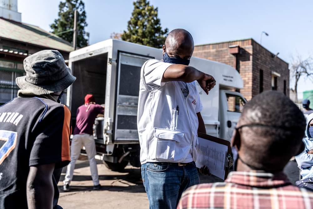 MSF staff speaking with people about how to keep safe during the COVID-19 pandemic