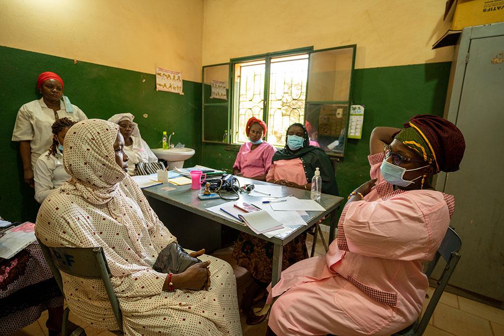 Diawara Fatouma Dicko, from the Yirimadio health centre, explains the movements of breast self-examination to a patient. 