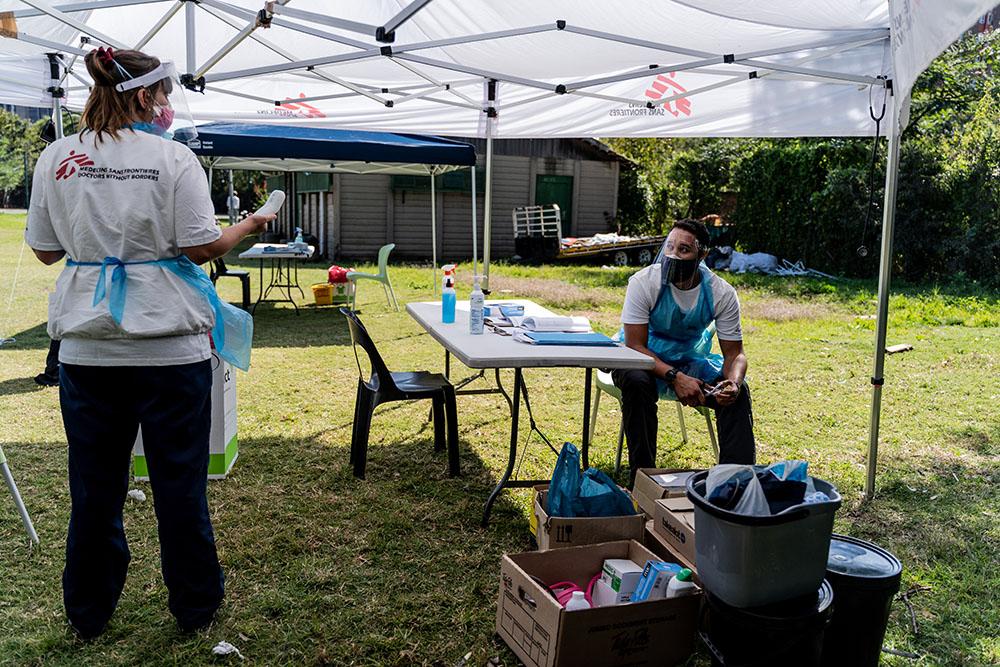 A nurse working with MSF and Dr Lindsay Demas a Doctor working with MSF prepare to consult patients at a mobile clinic set up at a homeless shelter in Johannesburg. The clinic forms part of MSF's response to the COVID-19 pandemic. 