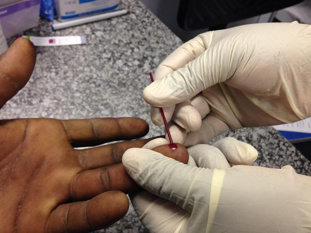 MSF staff member taking out blood for an HIV test