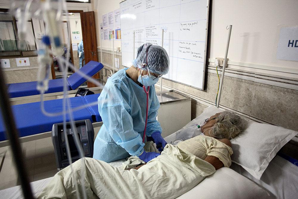 Nurse Heshu Komuni attends to an elderly ailing patient at the MSF High Dependency Unit (HDU) on her night shift. Bedside patient support by locally trained nurses and nurse aides was an important part of the response 