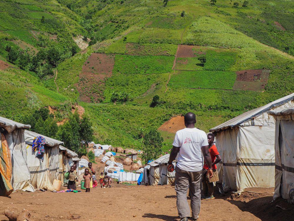 MSF staff member walking around in a internally displaced people's camp