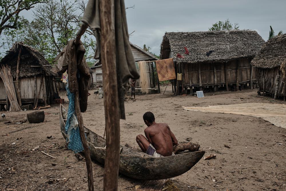 A fisherman repairing his canoe