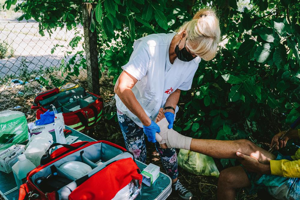 MSF nurse straps up the ankle of a patient