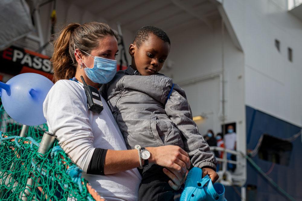 MSF Team member carries one of the rescued children