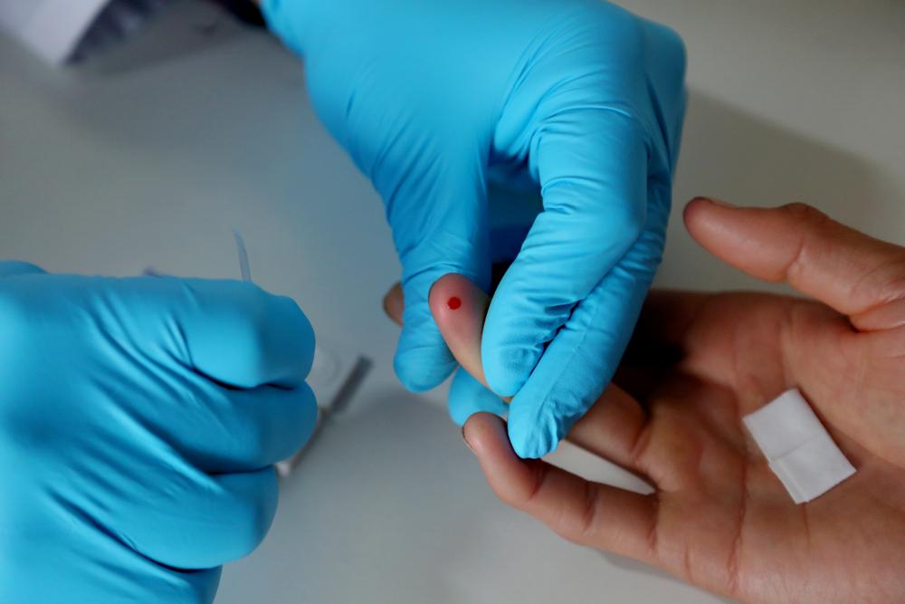 Doctor pricking a patient during HIV testing