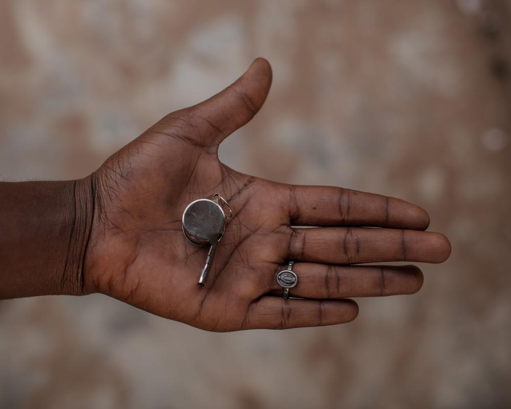 Am open palm with a whistle in it. This is given out in Nigeria to protect from sexual violence, and the devastating effects that follow social violence and exclusion 