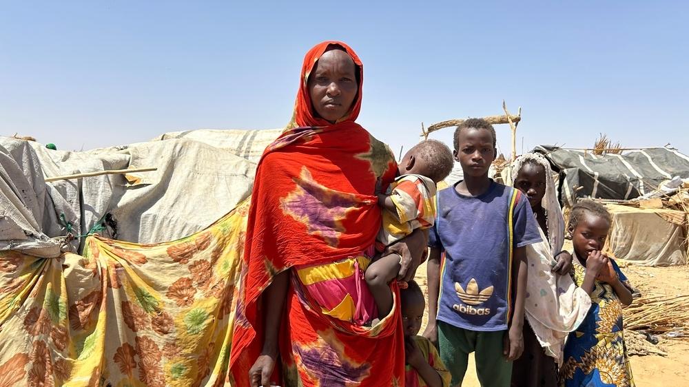 A woman and her children stand by their tent in a refugee camp in Chad