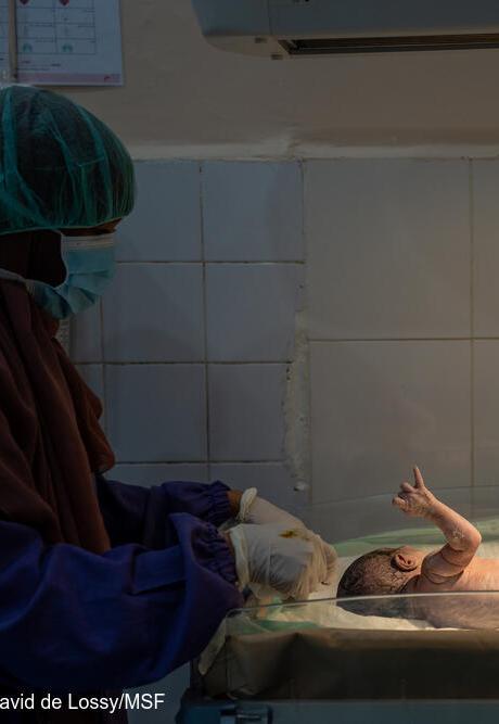 Child health: A midwife checks on a baby in an incubator