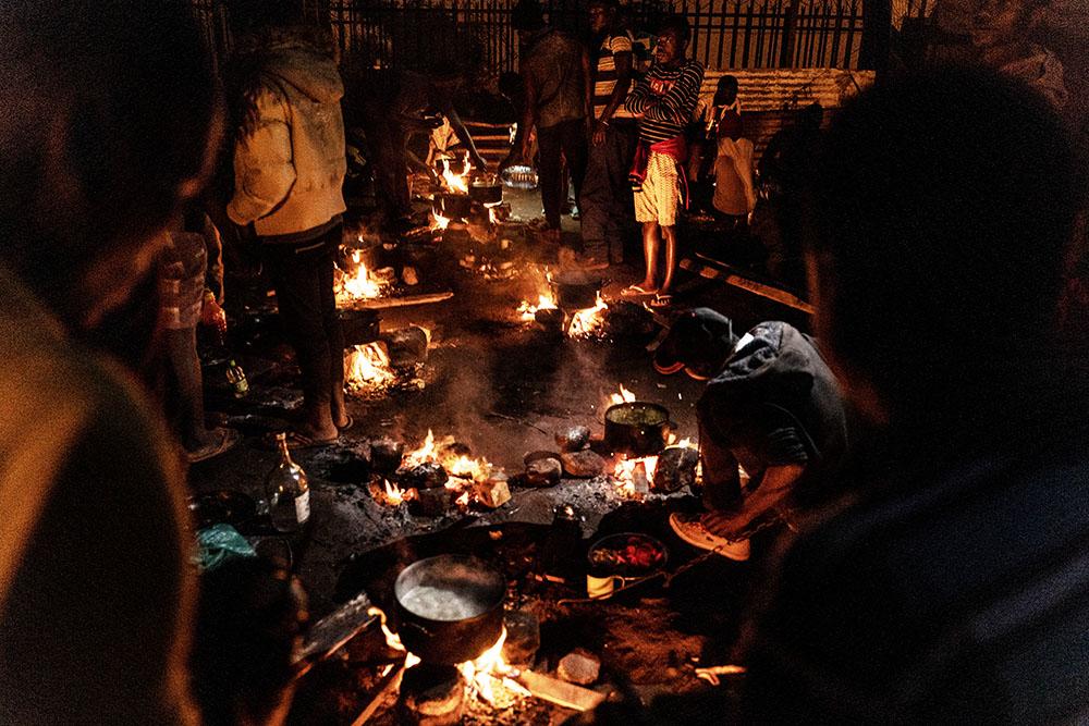 Migrants stand around the communal cooking area at a shelter for refugees in Musina, South Africa.