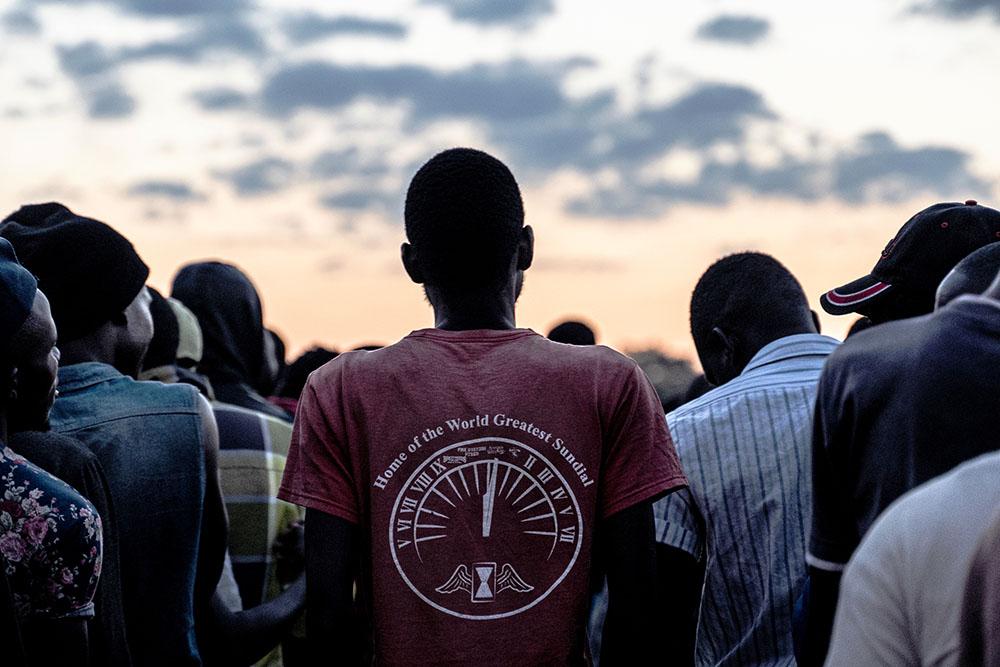 Men stand in line to receive blankets which were being distributed by a local group to men staying at a men's shelter for refugees in Musina, South Africa.