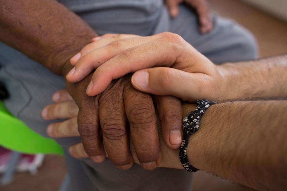 MSF staff and patient holding hands