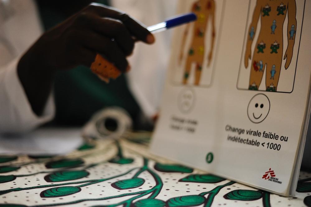 A doctor pointing to an medical illustration of the effects of HIV