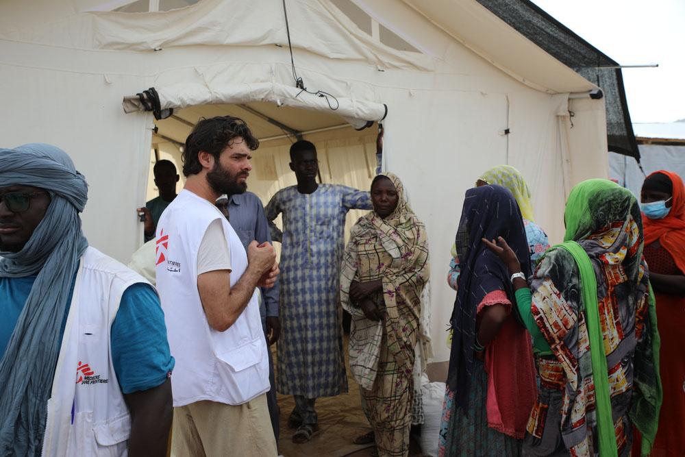 People queue outside the tent housing the MSF clinic at a refugee camp. It's easy for epidemics and pandemics to break out in these camps