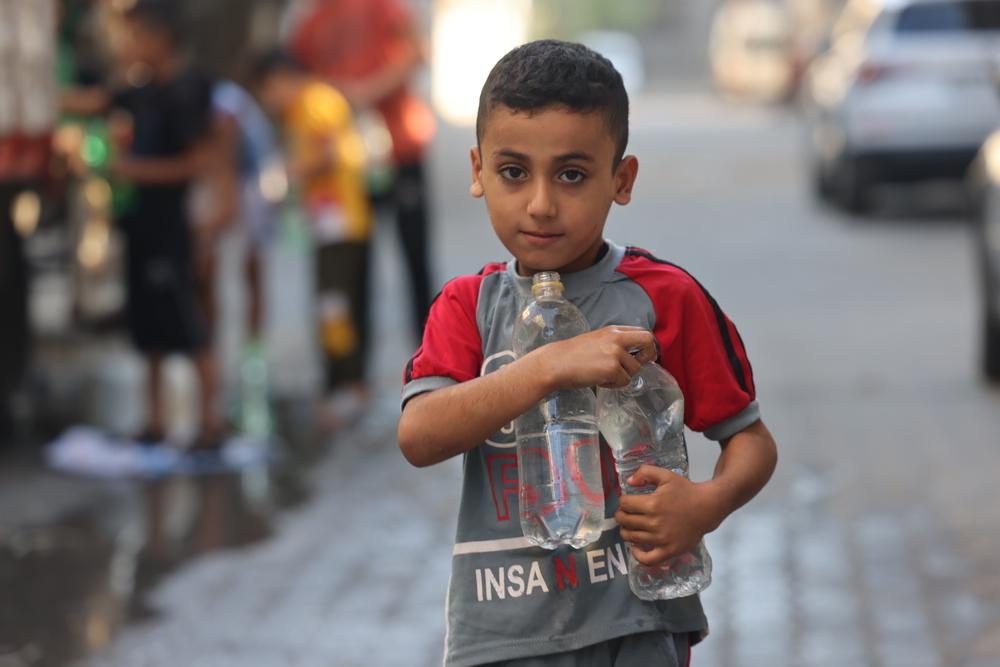 Image showing a boy carrying scarce water in Gaza, Palestine. 