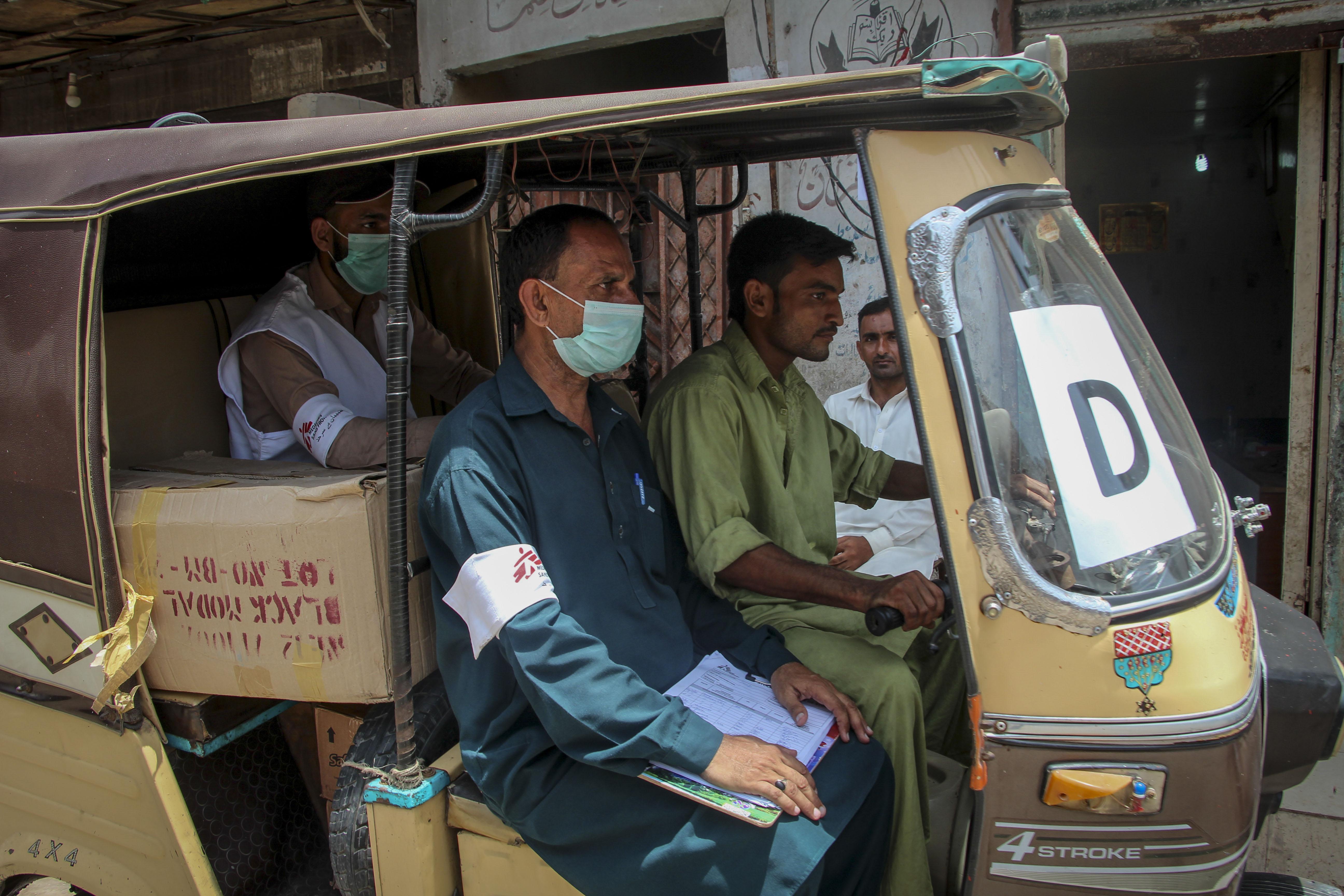 MSF staff and health promotor on a tuk-tuk distributing masks