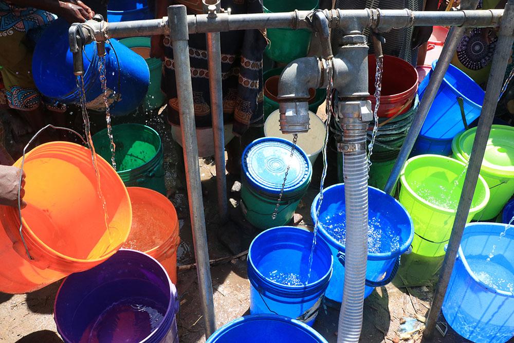 Dozens of buckets are seen at a water pumping station at Bangula camp for displaced people, where MSF is providing WASH facilities to people displaced by Tropical Cyclone Ana. 