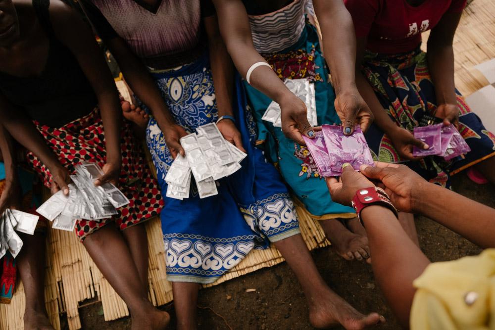 A picture of women holding condoms for distribution in Malawi