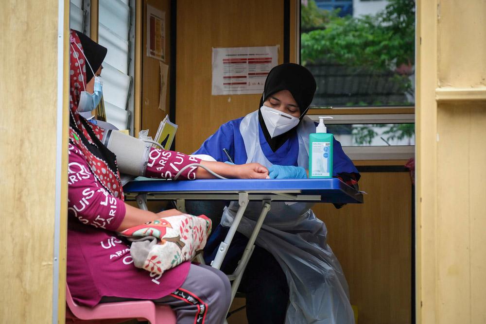 MSF triage nurse, Izyan, examines a patient