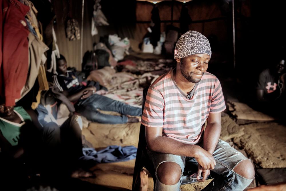 A migrant from the DRC sitting in a tent at a temporary shelter for migrants travelling into South Africa.
